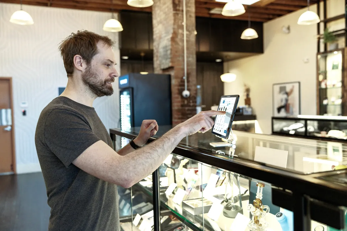 Un comerciante usa una tableta en el mostrador de su tienda